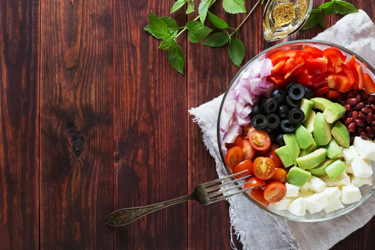 Bowl colorido con aguacate, vegetales frescos y queso